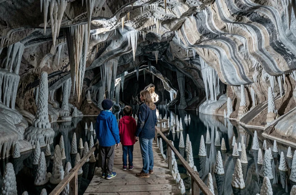 Mère et enfants observant les formations de sentinelles dans la Grotte de Trabuc dans le Gard
